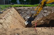 Bagger hebt auf einem Bauplatz im Neubaugebiet eine Baugrube aus