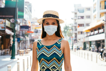 young brunette woman traveling in bangkok, thailand in popular khao san road during pandemic coronav