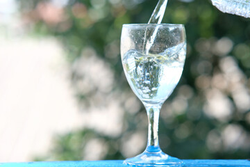 Poster - glass of water on wood table background and pouring drinking water