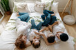© diignat - Beautiful pregnant woman lying on the bed with her husband and two awesome kids, boy and girl. Bare tummy, jeans, white shirts. Happy moments