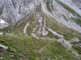 Poster - Horizontal  shot of a mountain covered with grass and stony on the edge