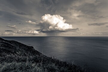 Poster - Beautiful landscape of the calm sea and rocky land under the gloomy sky