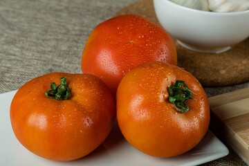 Canvas Print - Closeup shot of fresh tomatoes and garlic on the table