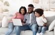 © Prostock-studio - Online Lottery. Excited African American Family Of Three Celebrating Win With Laptop
