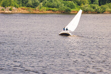 Yacht With White Sails At Volga River. Sailboat Tilted In A Gust Of Wind. Boat With A Sail Is Sinking.