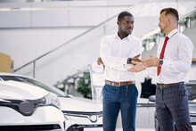 Confident Professional Salesman Talk About Characteristics Of Car To Customer Man, Black Business Man Want To Get Necessary Information About Auto Before Making Purchase, He Asks Questions