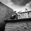 man playing violin or fiddle on an old roof