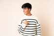 © luismolinero - Handsome man over isolated beige background pointing to the side to present a product