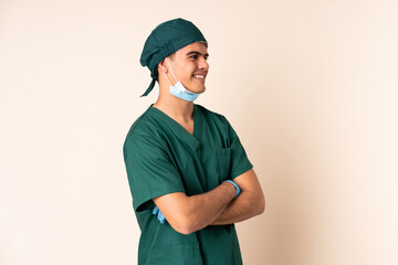 Wall Mural - Surgeon man in blue uniform over isolated background looking to the side