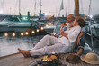 © Alessandro Biascioli - Senior couple drinking champagne and eating tropical fruits on sailboat vacation - Mature people having fun celebrate wedding anniversary on boat trip - Love relationship and travel lifestyle concept