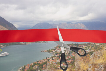 Wall Mural - The end of the quarantine of the coronavirus pandemic, the opening of the borders of countries. Scissors cut the red ribbon overlooking the Kotor Bay of the Adriatic Sea in Montenegro