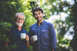 © chokniti - An adult hipster son and senior father drinking coffee in the garden at home, happy talking in the morning