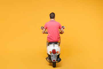 Wall Mural - Back rear view of young man guy in casual summer clothes driving moped isolated on yellow wall background studio portrait. Driving motorbike transportation concept. Mock up copy space.