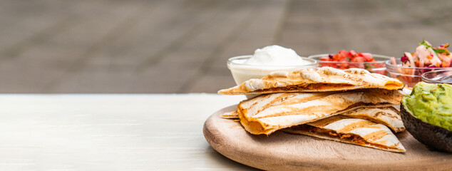 Mexican traditional authentic homemade quesadilla with pulled pork beef chili con carne serve with tomato salad and avocado guacamole and dip sauce