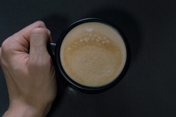 Sticker - High angle shot of a person holding a cup filled with cappuccino