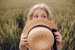 © Олег Кошевський - little girl with a straw hat. beautiful little girl with blond hair in a white dress in the background of a beautiful field. Girl with a bouquet of red poppies