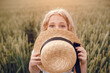 © Олег Кошевський - little girl with a straw hat. beautiful little girl with blond hair in a white dress in the background of a beautiful field. Girl with a bouquet of red poppies