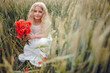 © Олег Кошевський - beautiful little girl with blond hair in a white dress in the background of a beautiful field. Girl with a bouquet of red poppies