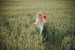 © Олег Кошевський - beautiful little girl with blond hair in a white dress in the background of a beautiful field. Girl with a bouquet of red poppies