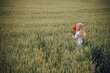 © Олег Кошевський - beautiful little girl with blond hair in a white dress in the background of a beautiful field. Girl with a bouquet of red poppies