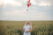 © Олег Кошевський - beautiful little girl with blond hair in a white dress in the background of a beautiful field. Girl with a bouquet of red poppies