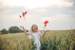 © Олег Кошевський - beautiful little girl with blond hair in a white dress in the background of a beautiful field. Girl with a bouquet of red poppies