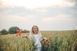 © Олег Кошевський - beautiful little girl with blond hair in a white dress in the background of a beautiful field. Girl with a bouquet of red poppies