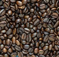 Fresh coffee beans scattered as a background or texture.