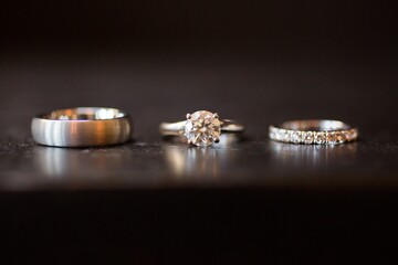 Sticker - Closeup shot of  3 types of silver wedding rings on the black table