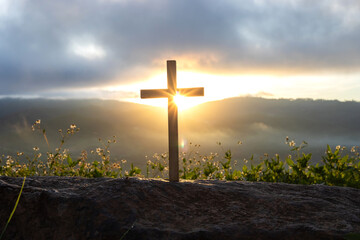 Silhouettes of crucifix symbol with bright sunbeam on the colorful sky background