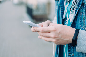 A man holding a smart phone and typing a message