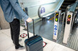 © zephyr_p - Travel insurance concept. Male tourist carrying suitcase luggage at escalator in airport terminal.