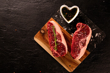 Wall Mural - Two raw picanha steaks with spices on a dark background