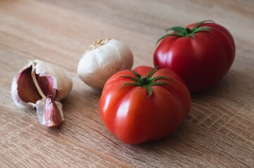 Sticker - Closeup shot of tomatoes and garlic isolated on a wooden surface