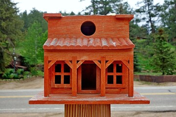 Poster - Closeup shot of a red wooden birdhouse with house-shaped design