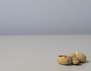 Poster - Closeup shot of four pistachios on the right lower corner on a grey background