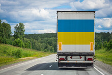 A  Truck With The National Flag Of Ukraine Depicted On The Back Door Carries Goods To Another Country Along The Highway. Concept Of Export-import,transportation, National Delivery Of Goods