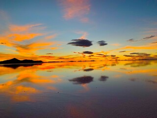 Wall Mural - Stunning orange sunset and amazing landscape on salt lake in Salt Marsh, Salar de Uyuni, Bolivia. The most amazing place in the world, wonder of nature.