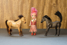 A Doll Girl And Two Toy Horses