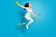 Full length body size profile side view of her she nice attractive funky childish comic maid jumping riding broom like horse isolated on bright vivid shine vibrant blue color background