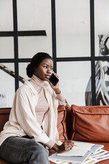 African woman interior designer talking by mobile phone