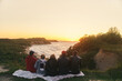 © Dima Anikin - A group of friends watching the sunset at sea. View from the back. High-quality photo