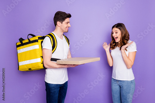 Portrait of shocked girl impressed fast pizza pizzeria express delivery guy courier hold box give wear white t-shirt denim jeans isolated over purple color background