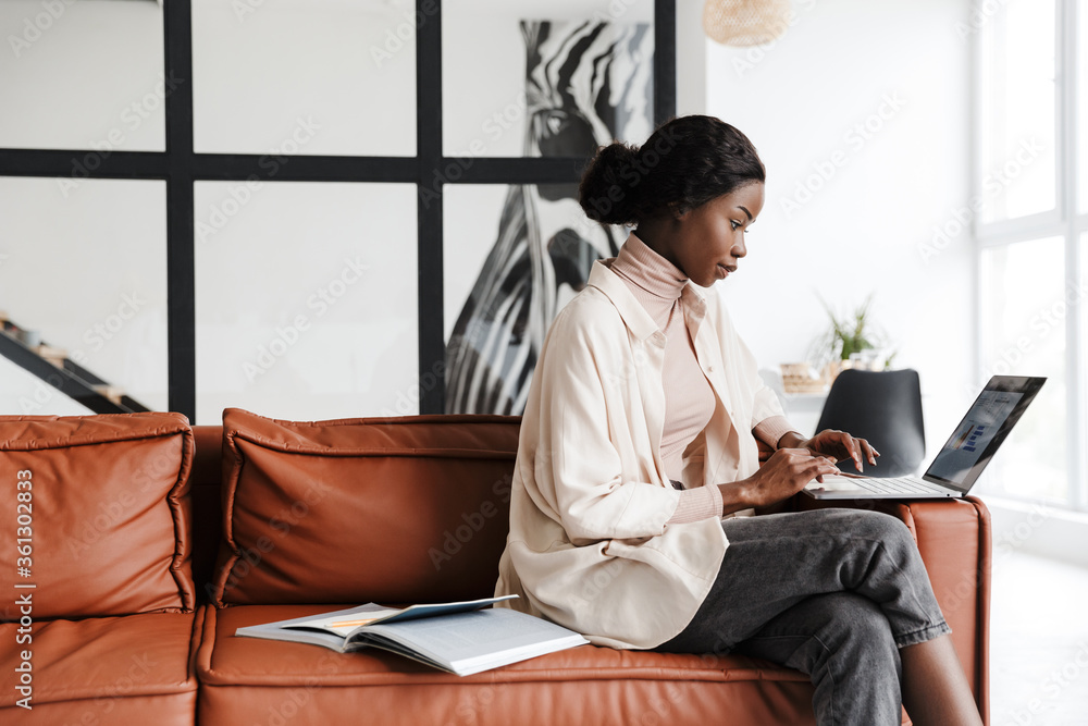 Attractive young smiling african woman sitting on a couch Stock Photo ...