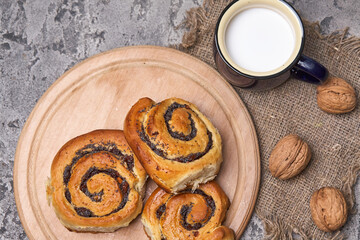 Sticker - Basket of homemade buns with jam, served on old wooden table with walnuts and cup of milk