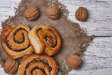 Wall Mural - Tasty buns with raisins on a white rustic wooden table. fresh bakery. breakfast. bread. top view