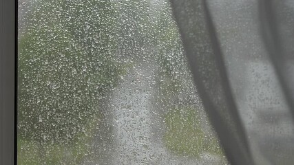 Rainy weather. Mosquito net ON THE WINDOW. Raindrops on a mosquito net.