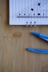 Poster - Top view of a compass with an open notebook and a ruler on a wooden surface