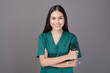 © tonefotografia - a female doctor wearing a green scrubs and stethoscope is on grey background studio