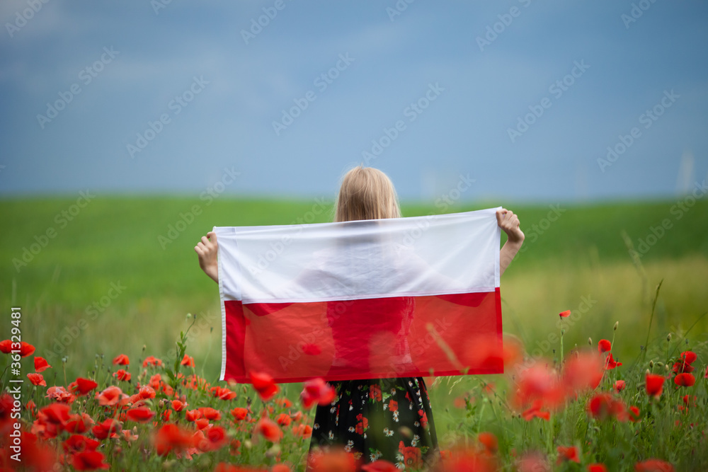 Obraz na płótnie Blond girl holding flag of Poland in the poppy field. Back  view. Polish Flag Day. Independence Day. Travel and learn polish language concept. w salonie